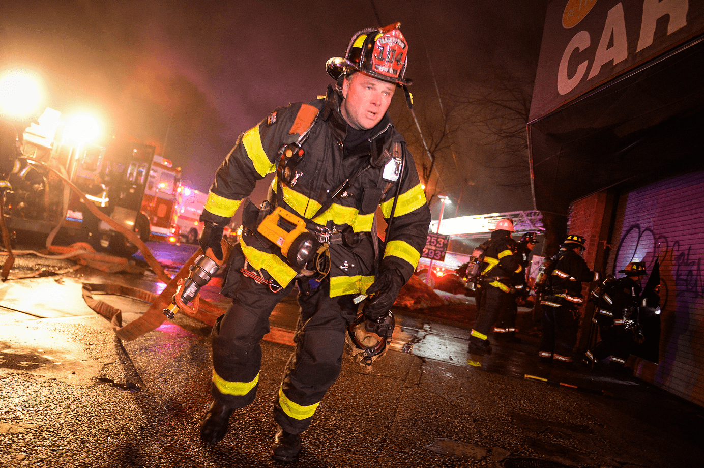 Volunteer firefighter leeb stretching a line at a carwash fire, 2018